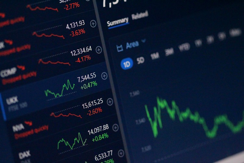 Person reviewing diversified investment data and performance metrics on multiple screens