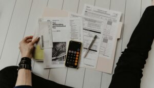 Financial professional reviewing tax and investment documents at desk with calculator and charts