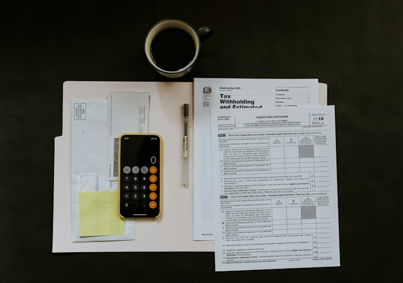 Organized desk with tax documents, financial statements, and calculator for capital gains tax forecasting and planning