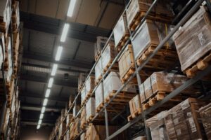 Organized warehouse shelves with labeled inventory boxes and stock items representing parcel-level lot organization